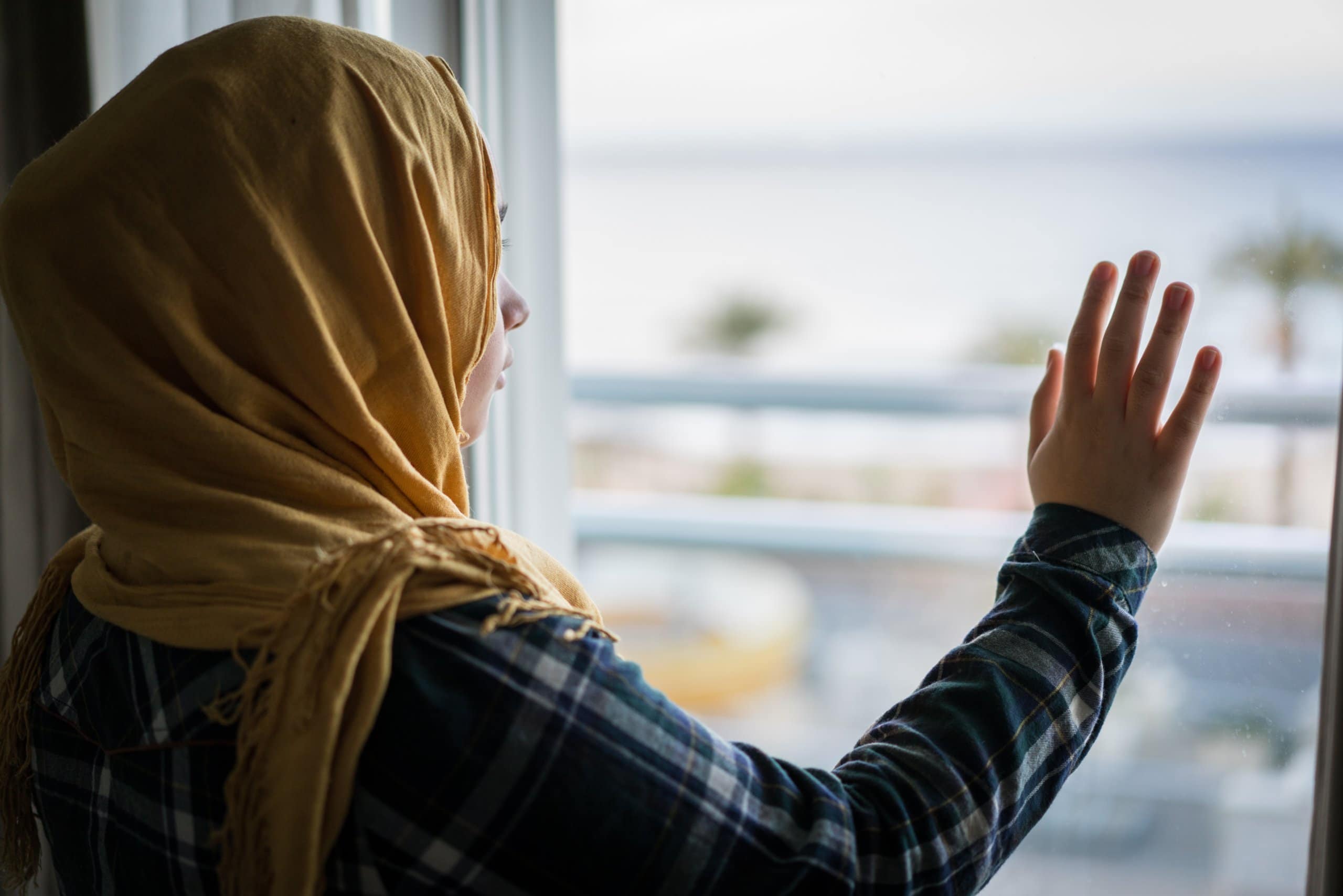 Muslim,Woman,Looking,From,Hotel,Apartment,Window,At,The,Sea